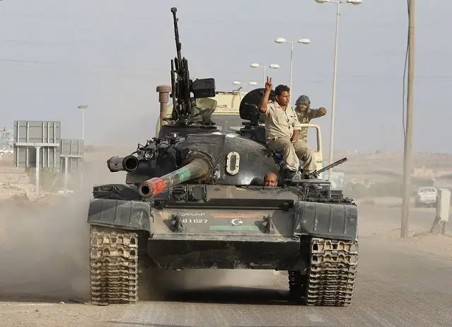 Members of Libya's government forces NTC ride on a tank near Sirte, October7, 2011. Libyan government forces launched their largest assault yet on Muammar Gaddafi's hometown of Sirte on Friday, firing heavy artillery at the last major bastion of support for the deposed leader. 