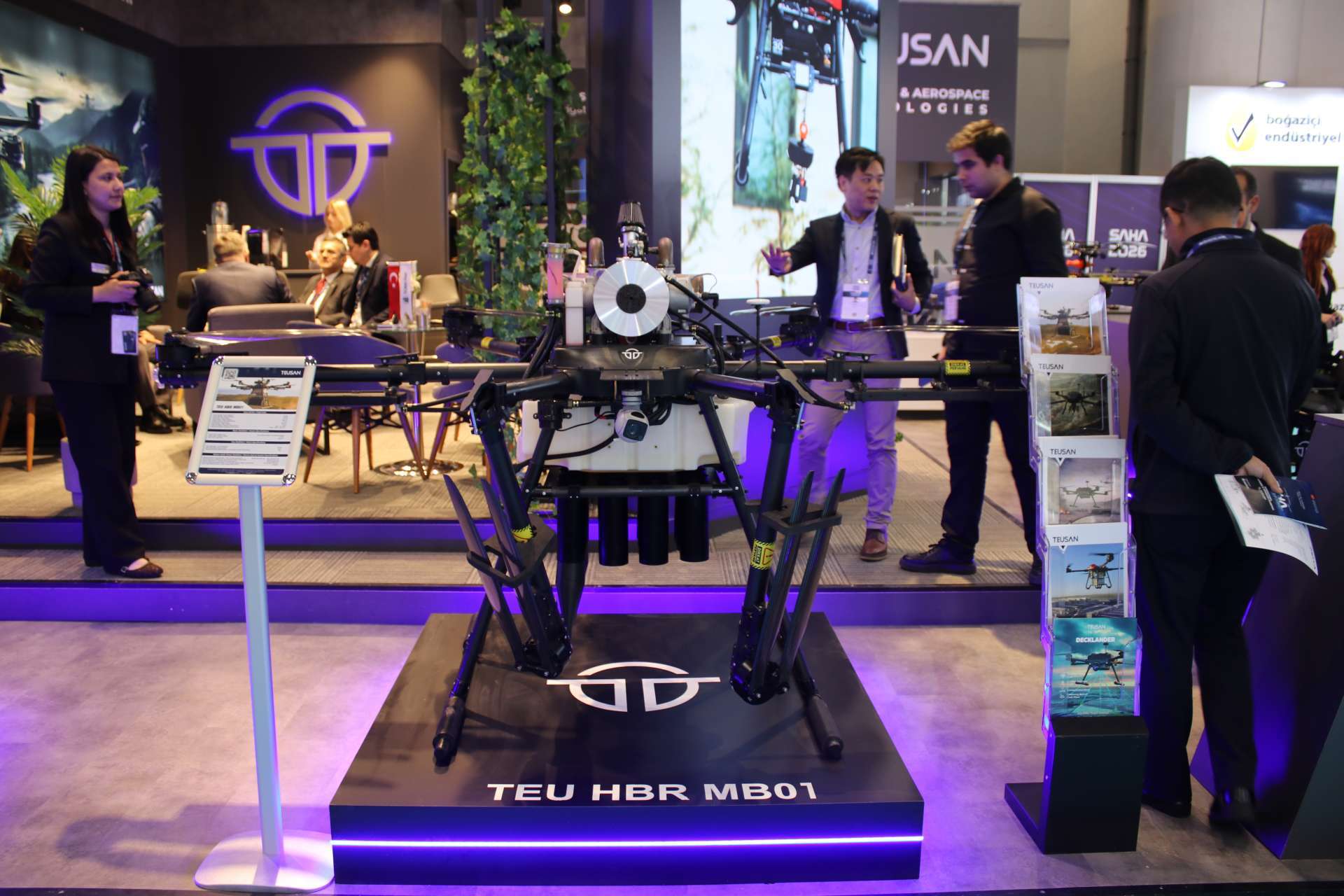 Turkish company TEUSAN displayed the TEU HBR MB01 hybrid multirotor UAV at SAHA 2026, showing a 50 kg payload-class drone with a two-hour endurance and automatic bomb-release mechanism for tactical resupply, surveillance, and controlled munition delivery (Picture source: Army Recognition Group).
