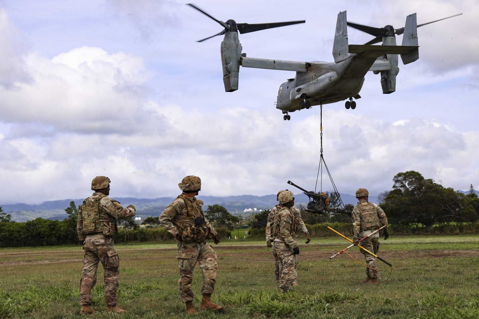 U.S. Army Soldiers from Bravo Battery, 3rd Battalion, 7th Field Artillery Regiment, 25th Infantry Division move clear after sling-loading an M119 105 mm howitzer beneath a U.S. Marine Corps MV-22B Osprey during training at Schofield Barracks, Hawaii, on August 19, 2026.