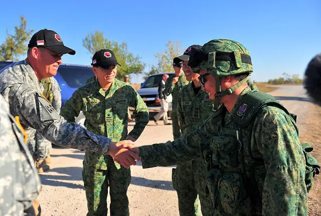 The Commander of the SAF Training and Doctrine Command Brigadier-General Lim Hock Yu (second from left) and the Commanding General of the US Fires Center of Excellence and Fort Sill Major-General David Halverson (left) interacting with SAF personnel after the live-firing exercise.
