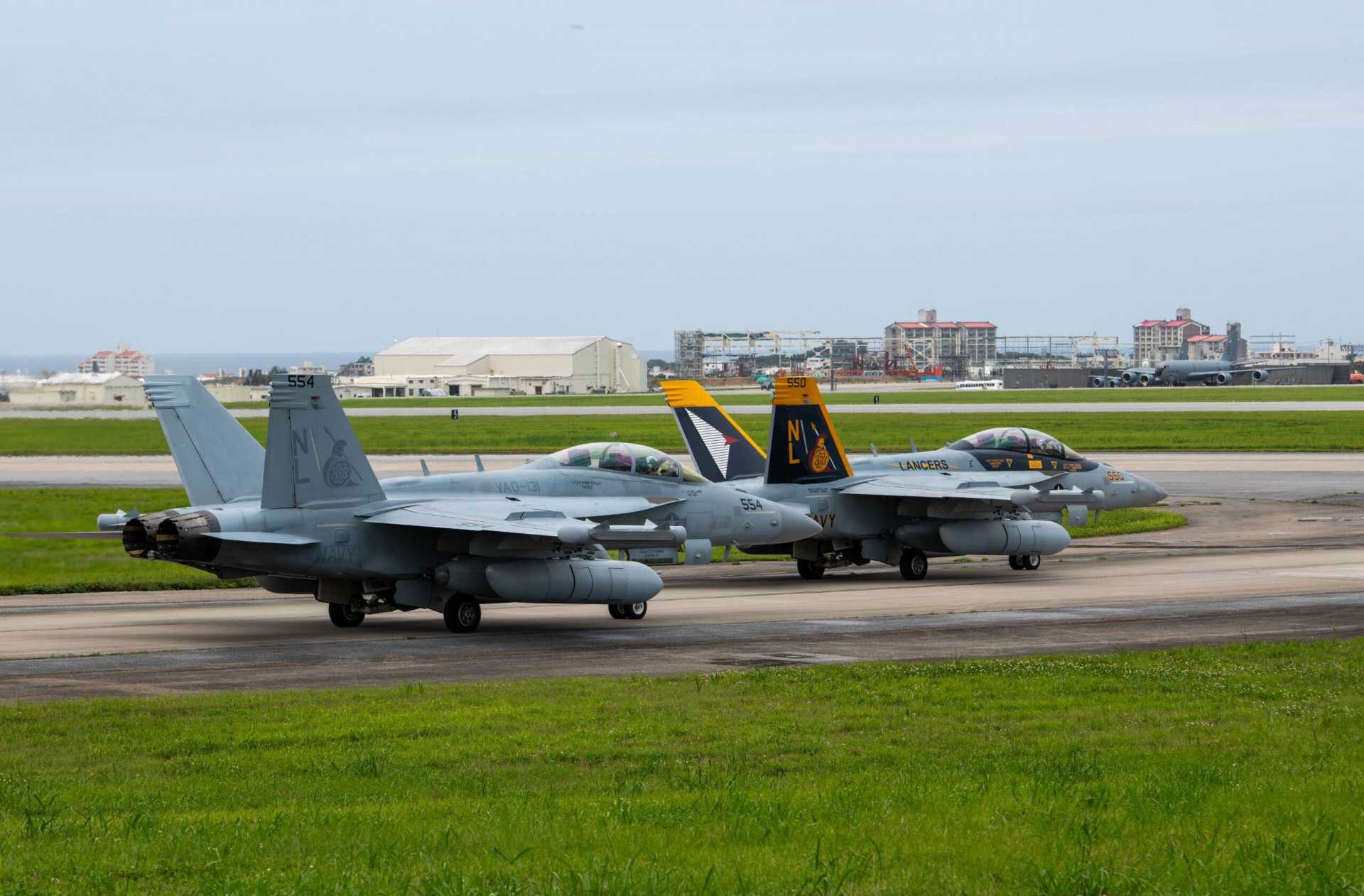Two U.S. Navy EA-18G Growlers taxi at Kadena Air Base, Japan, during a readiness exercise on May 6, 2025. Protecting forward air bases and high-value aircraft from drone and cruise missile attacks is becoming a critical requirement for U.S. forces in the Indo-Pacific. (Picture source: U.S. Department of War/Defense)
