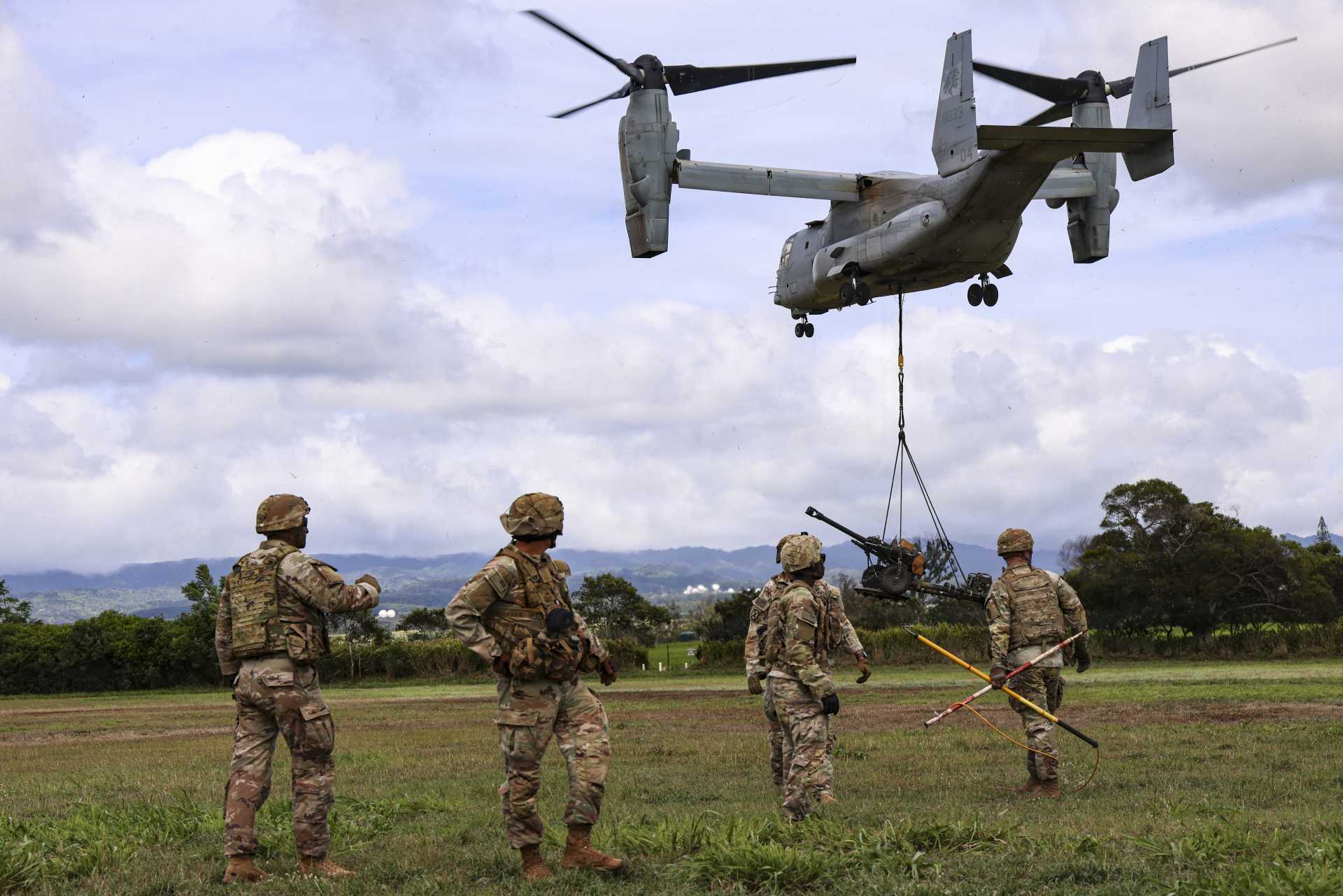 U.S. Army Soldiers from Bravo Battery, 3rd Battalion, 7th Field Artillery Regiment, 25th Infantry Division move clear after sling-loading an M119 105 mm howitzer beneath a U.S. Marine Corps MV-22B Osprey during training at Schofield Barracks, Hawaii, on August 19, 2026.