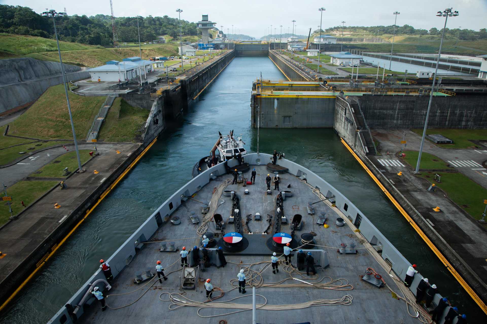 Panamanian line handlers secure USS San Antonio (LPD 17) during its Panama Canal transit on Aug. 1, 2026. The operation marked the first transit by a U.S. Marine Expeditionary Unit through the canal since 2008, highlighting the U.S. Navy and U.S. Marine Corps' rapid expeditionary mobility. (U.S. Marine Corps photo)