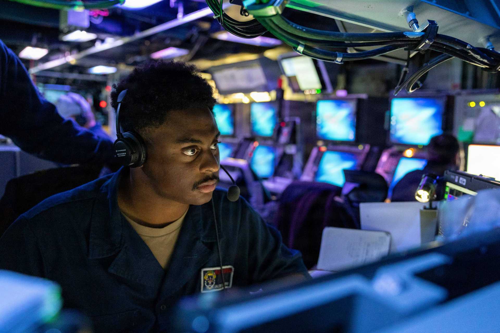 A U.S. Navy Fire Controlman monitors the Aegis Weapon System aboard the Arleigh Burke-class guided-missile destroyer USS Mustin (DDG 89) during a combat systems training drill in the Indian Ocean on June 25, 2026.