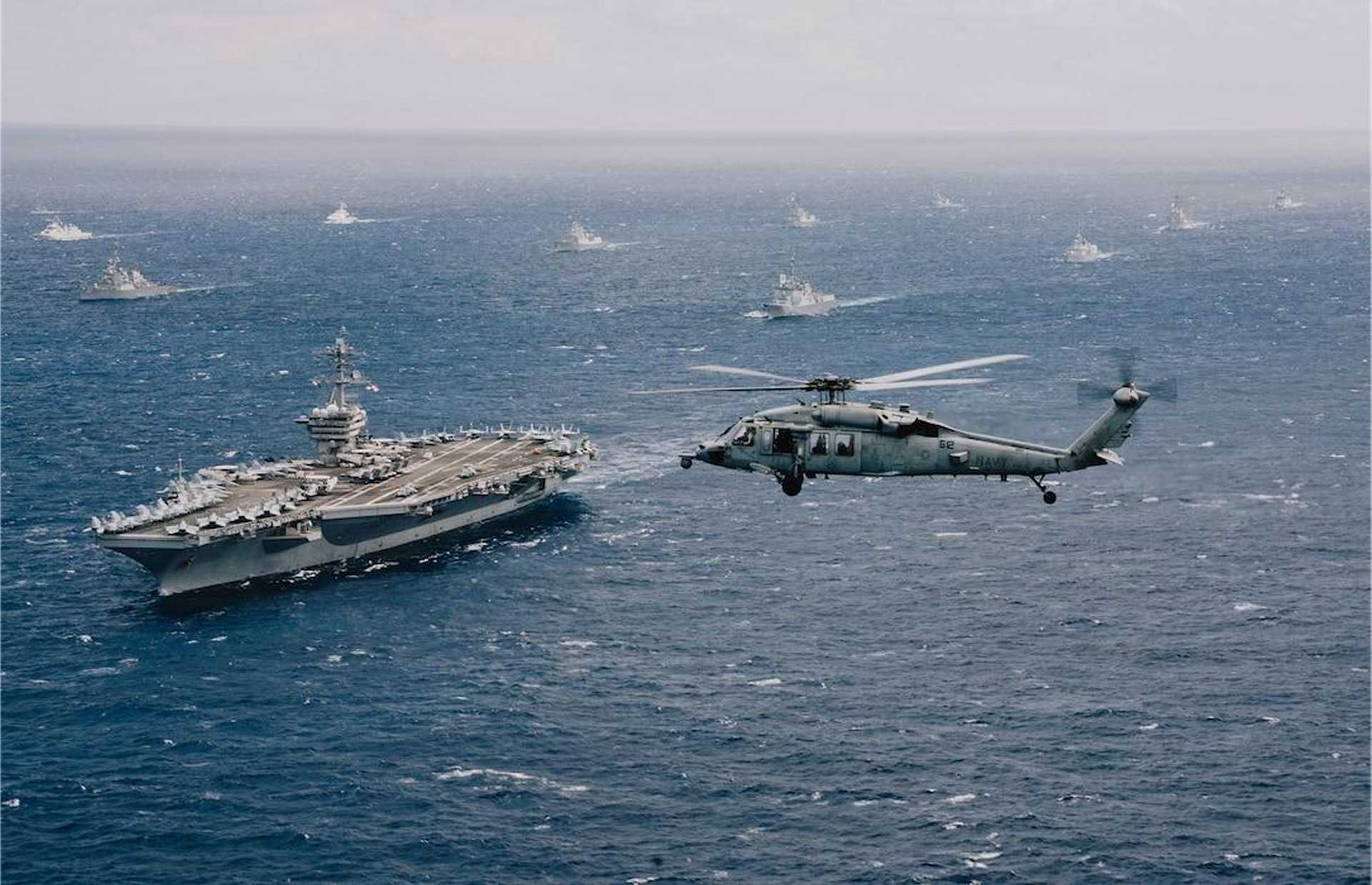 U.S. Navy Nimitz-class aircraft carrier USS Theodore Roosevelt (CVN 71) leads a multinational formation during RIMPAC 2026 in the Pacific. U.S. Navy commanders are examining how unmanned underwater vehicles could eventually transfer critical components between aircraft carriers and submerged submarines.