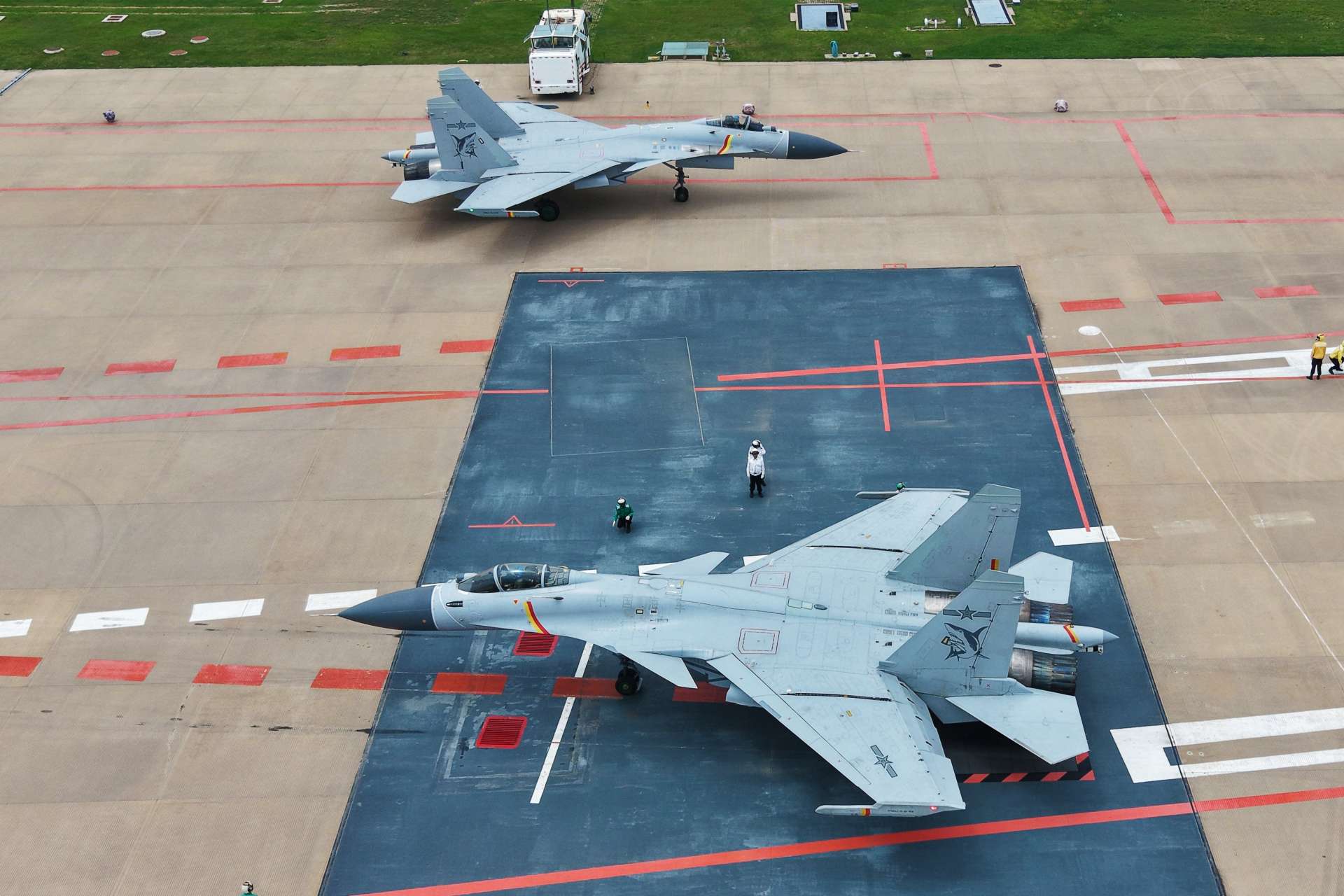 Chinese J-15 carrier-based fighters conduct land-based takeoff and landing drills designed to expand pilot qualification, deck-handling proficiency, and sortie-generation capacity for the Liaoning, Shandong, and Fujian aircraft carriers (Picture source: Chinese MoD).