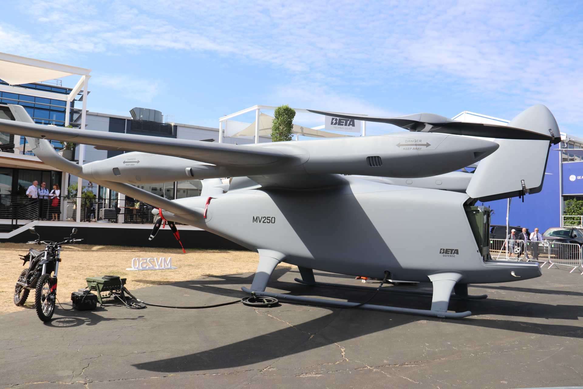U.S. Beta Defense unveils the MV250 hybrid-electric VTOL multi-mission utility aircraft at the Farnborough International Airshow 2026. Designed for autonomous logistics and distributed military operations, the aircraft combines long-range vertical flight, a 2,000-pound (907 kg) payload capacity, hybrid-electric propulsion, and rapid mission reconfiguration for future expeditionary forces. (Picture source: Army Recognition Group)
