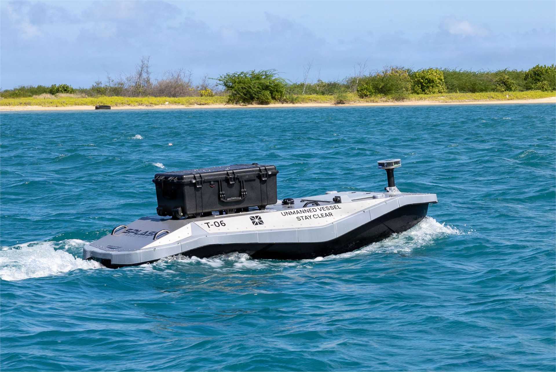 A digitally crewed uncrewed surface vessel departs Sand Island near Honolulu, Hawaii, carrying components for an embarked additive manufacturing system aboard the Wasp-class amphibious assault ship USS Essex (LHD 2) during Exercise Rim of the Pacific (RIMPAC) 2026 on July 7, 2026.