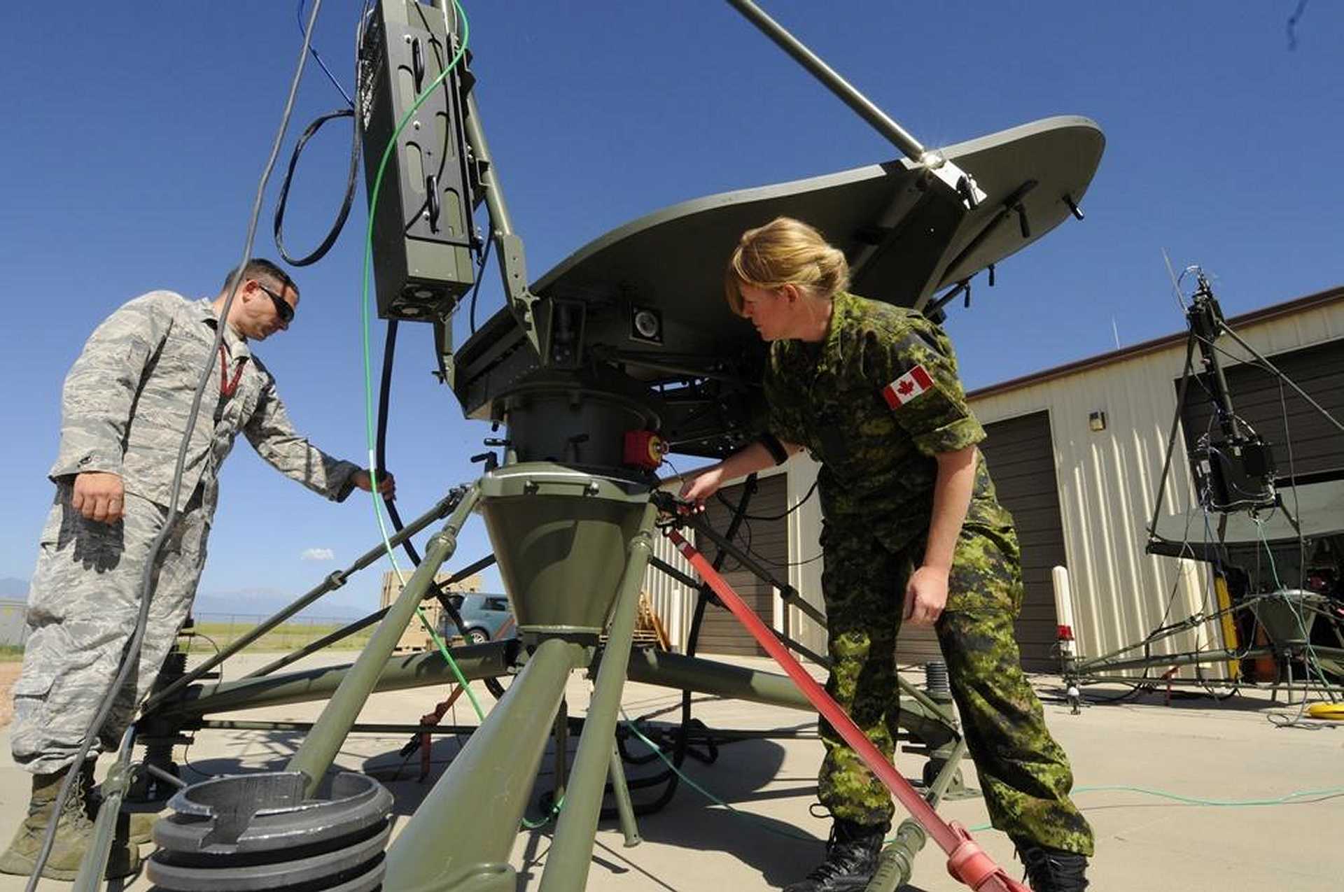 A U.S. Space Force technician operates a satellite communications antenna terminal at Kirtland Air Force Base, New Mexico. The service is developing new compact, jam-resistant communications terminals to strengthen the resilience of military space networks. (Picture source: U.S. Department of War/Defense)