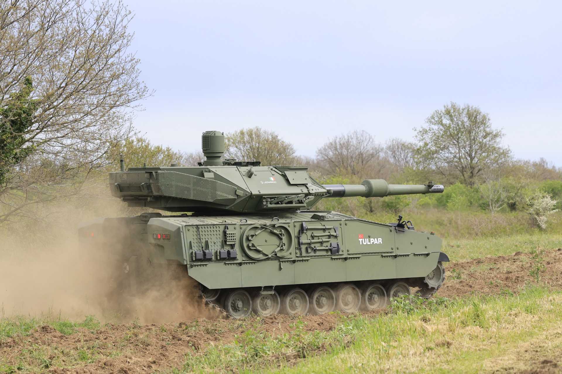 Turkish Otokar TULPAR medium tank fitted with Italian Leonardo’s HITFACT MkII 120 mm turret during live-fire trials, validating NATO-standard 120 mm firepower in both static and moving conditions.