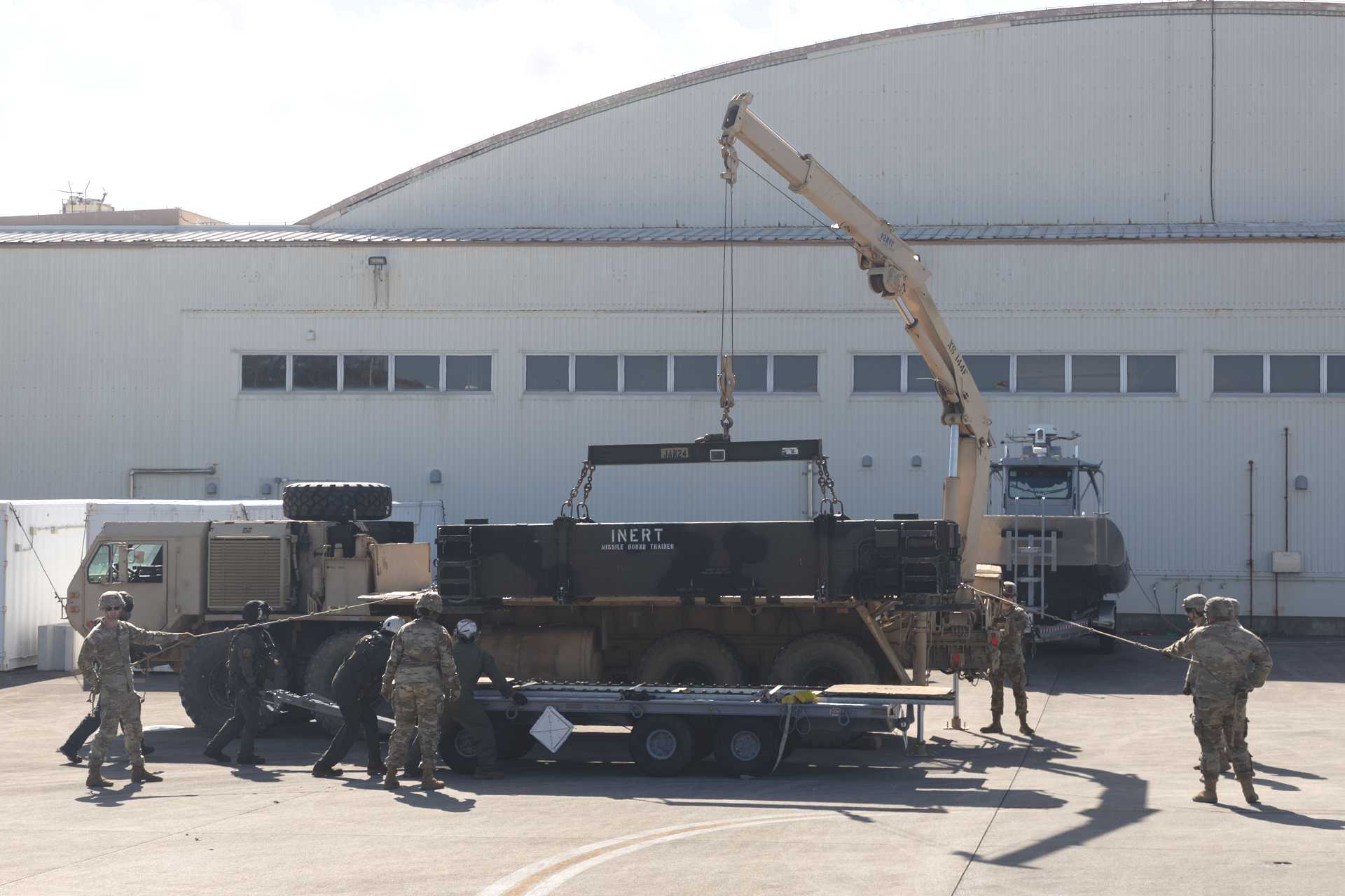 U.S. Marines and Army air defense Soldiers prepare a PAC-3 training canister for transport by CH-53E in Okinawa, highlighting Patriot mobility as the Pentagon expands PAC-3 MSE production to strengthen missile stocks against growing air and ballistic missile threats.