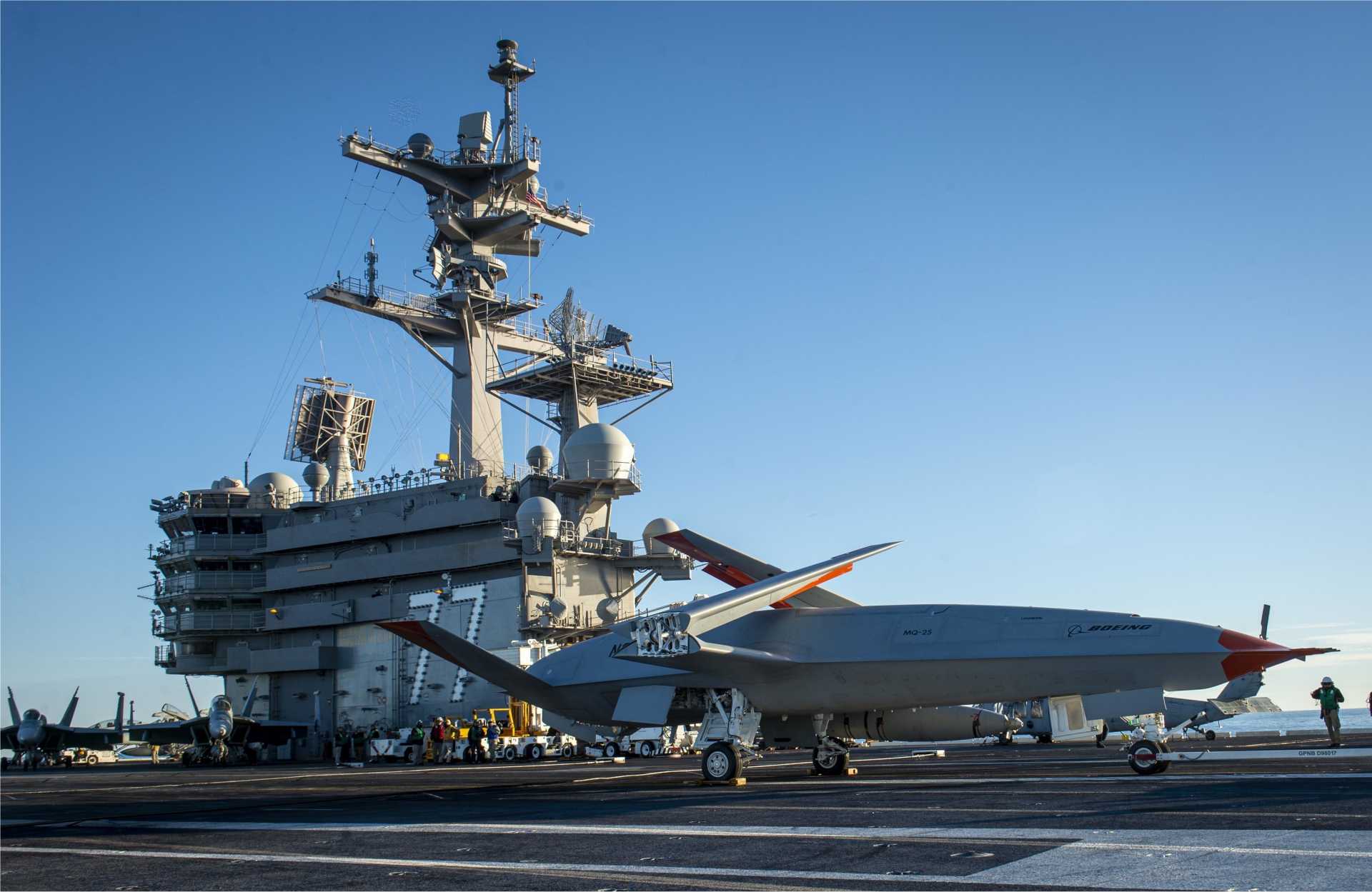 A Boeing MQ-25 Stingray unmanned tanker receives flight-deck operating directions aboard the U.S. Navy aircraft carrier USS George H.W. Bush (CVN 77). Designed as the U.S. Navy’s first operational carrier-based unmanned aircraft for aerial refueling and ISR missions, the MQ-25 is now also being examined for potential land-based operation, which could broaden its future role in distributed Indo-Pacific missions and allied air operations.