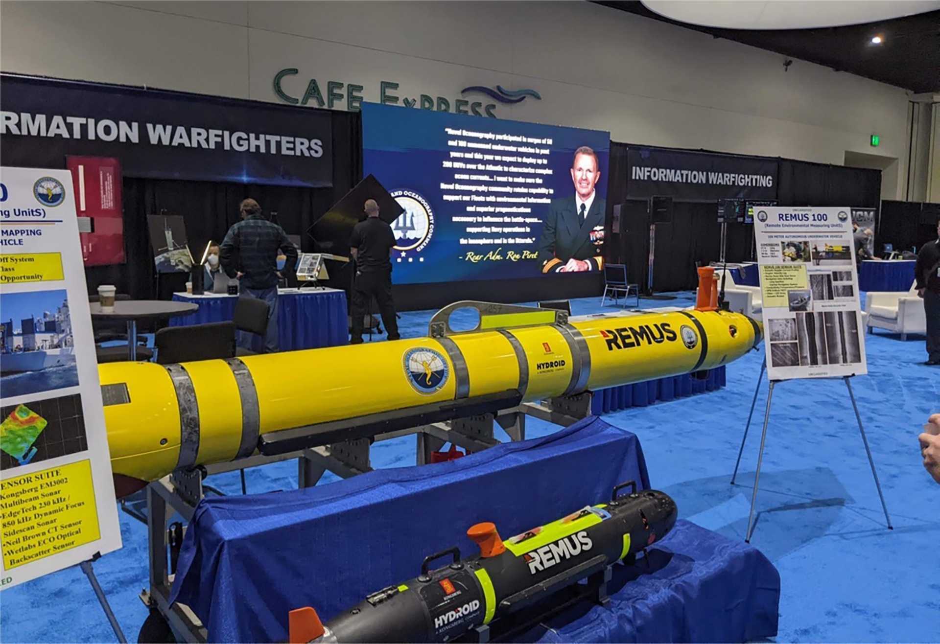 The U.S. Naval Oceanography booth displays Remote Environmental Measuring Units (REMUS) unmanned underwater vehicles (UUVs), designed to support autonomous undersea missions including oceanographic survey, environmental data collection, reconnaissance, and mine countermeasures.