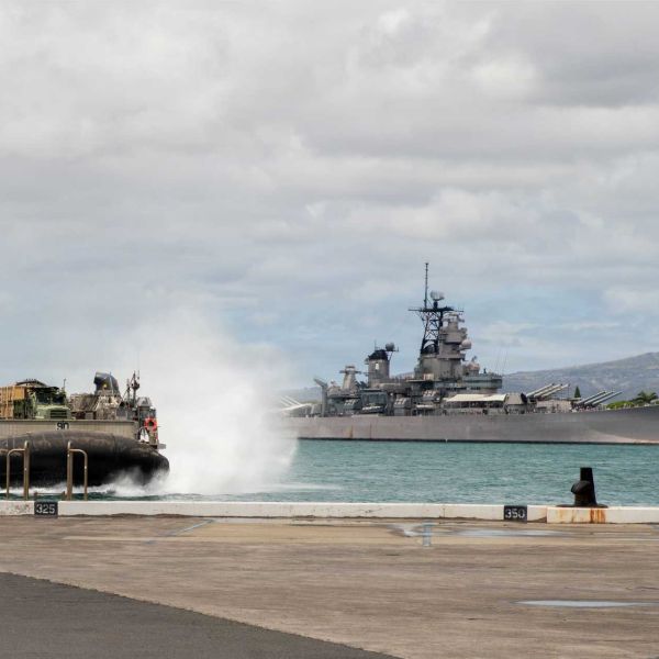 U.S. Navy Landing Craft, Air Cushion (LCAC) 90, assigned to Assault Craft Unit 5, passes the USS Missouri before entering the well deck of the Wasp-class amphibious assault ship USS Essex (LHD 2) at Joint Base Pearl Harbor-Hickam, Hawaii, on August 2, 2026.