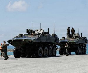 U.S. Marines with the 3rd Assault Amphibian Battalion, 31st Marine Expeditionary Unit, guide Amphibious Combat Vehicles (ACVs) ashore from USS Rushmore (LSD 47) at White Beach Naval Facility, Okinawa, Japan, on July 23, 2026, reinforcing the U.S. Marine Corps' forward-deployed expeditionary presence in the Indo-Pacific.