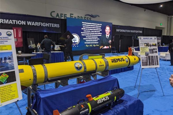 The U.S. Naval Oceanography booth displays Remote Environmental Measuring Units (REMUS) unmanned underwater vehicles (UUVs), designed to support autonomous undersea missions including oceanographic survey, environmental data collection, reconnaissance, and mine countermeasures.