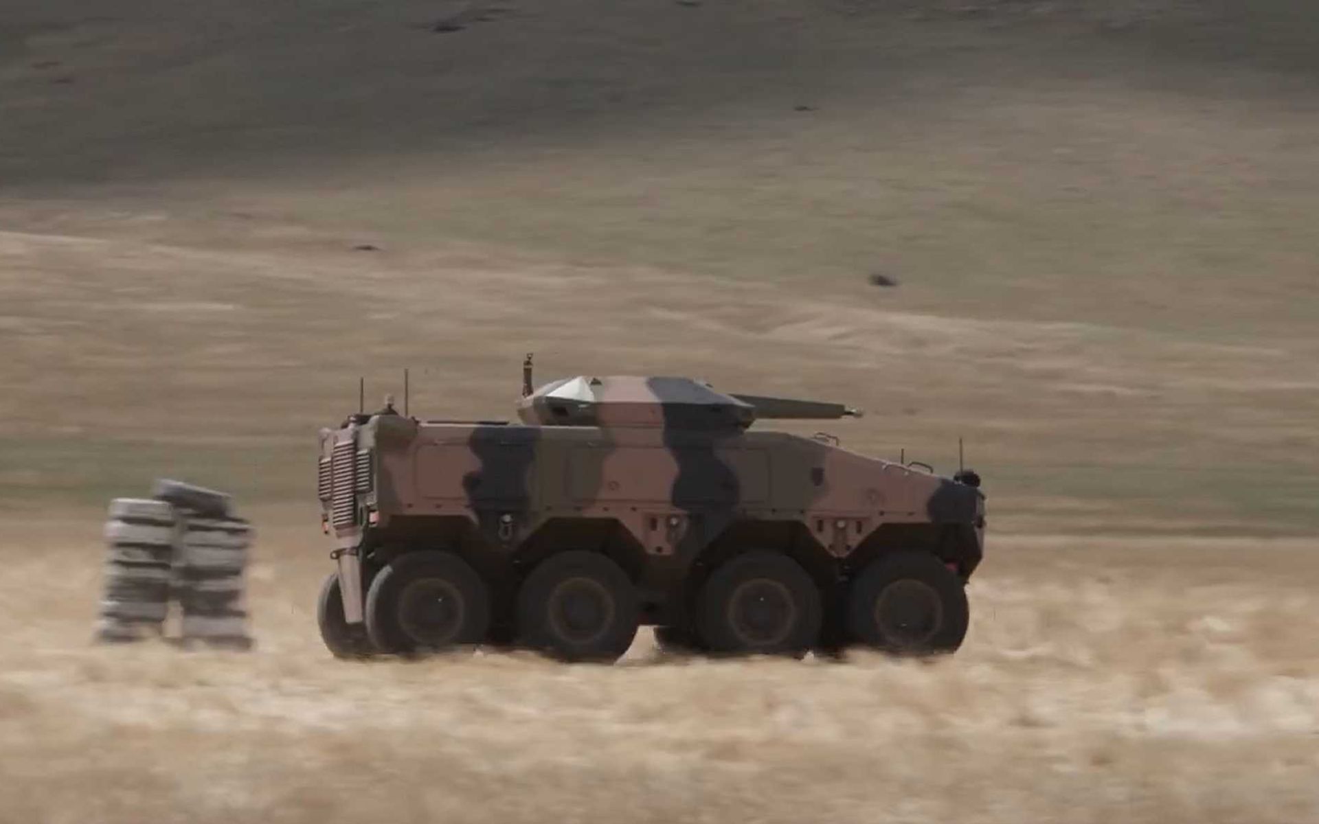 8x8 armored vehicle equipped with the ATLAS autonomous driving system undergoing mobility trials during BAE Systems Australia testing, demonstrating driverless maneuver capability in support of future crewed and uncrewed armored operations.