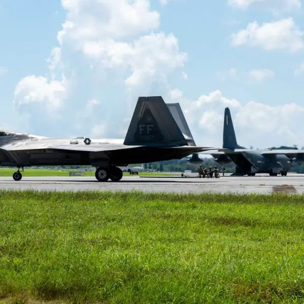 A U.S. Air Force F-22 Raptor assigned to the 27th Expeditionary Fighter Squadron taxis after completing a forward arming and refueling point operation during Beverly Beach 26-1 at Kadena Air Base, Japan, Aug. 4, 2026. Nearby, an MC-130J Commando II is refueled by Airmen from the 18th Logistics Readiness Squadron, demonstrating how dispersed fuel support can sustain rapid fighter regeneration during a regional contingency.