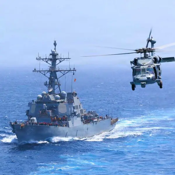 U.S. Navy USS Donald Cook (DDG 75) transits the Arabian Sea alongside an MH-60S Seahawk as U.S. forces intensify maritime interdiction operations against Iran, with CENTCOM reporting five commercial vessels diverted and one disabled as of July 18, 2026.