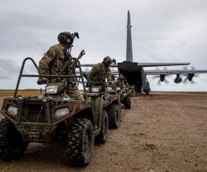 U.S. Army Green Berets from the 10th Special Forces Group load all-terrain vehicles onto a U.S. Air Force MC-130J Commando II during Operation POLAR DAGGER in Wales, Alaska, on August 17, 2024, demonstrating rapid Arctic infiltration and mobility near the Bering Strait.