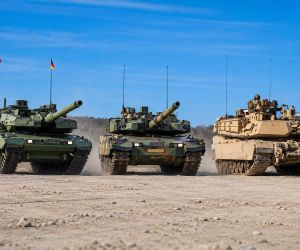 German Leopard 2A8 at left, South Korean K2 Black Panther at center, and U.S. M1A2 SEPv3 Abrams at right illustrate the three main battle tank approaches shaping Europe’s armored modernization, where firepower and protection are increasingly weighed alongside mobility, delivery speed, industrial capacity, and local production.