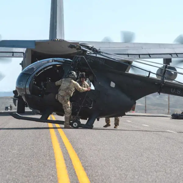 U.S. special operations aviation assets, including an MC-130J Commando II and MH-6M Little Bird, demonstrate forward deployment and infiltration capabilities similar to those used in high-risk personnel recovery missions in denied environments.