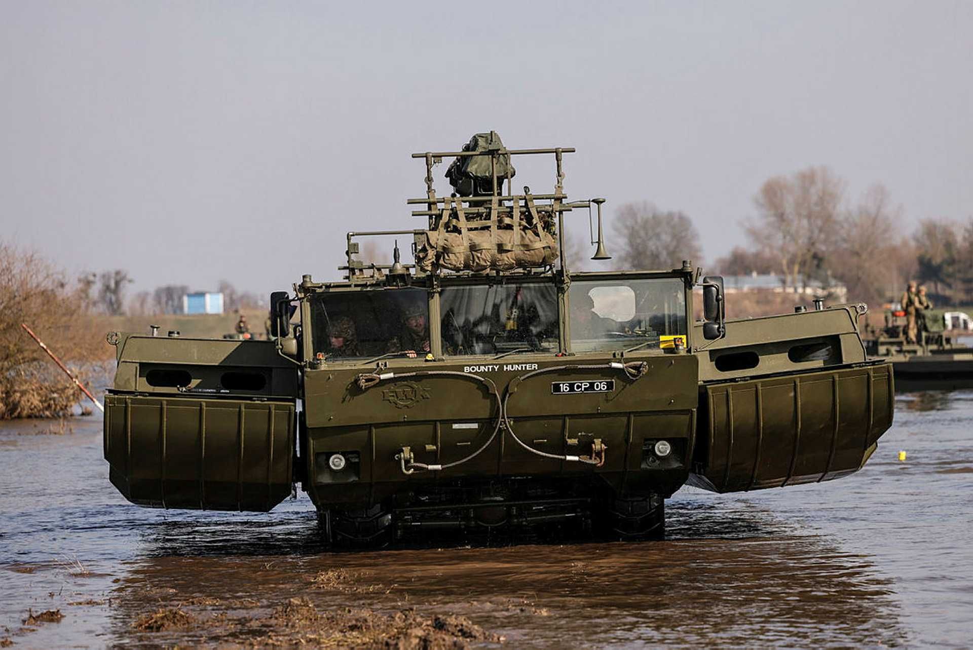 British Army M3 amphibious vehicle deploying in ferry mode during a river crossing exercise, demonstrating rapid wet gap bridging capability with full combat load under NATO operational standards.