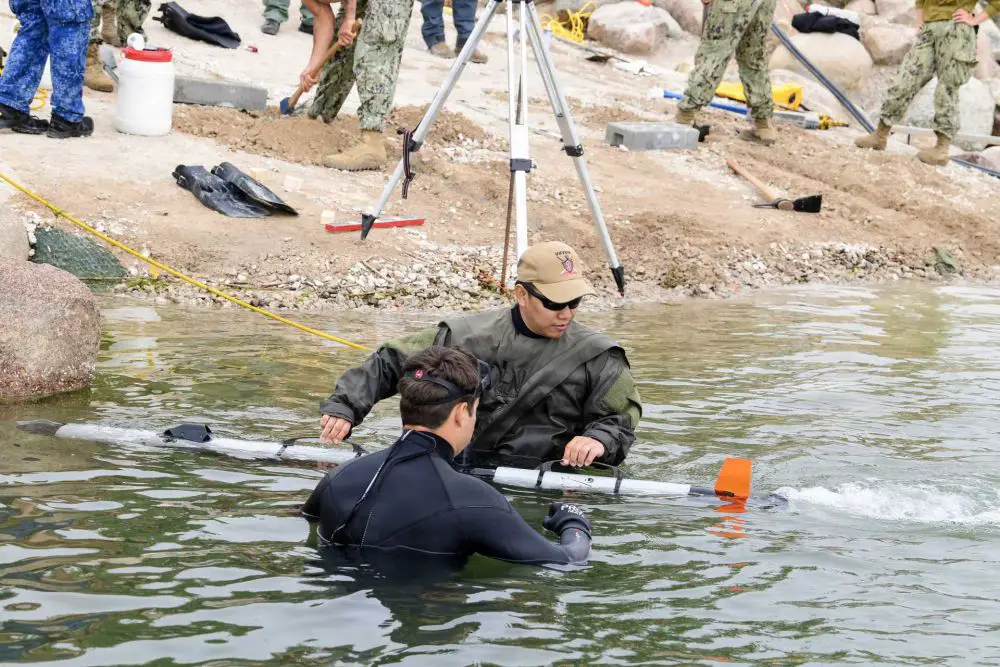 U.S. Navy personnel from Unmanned Undersea Vehicle Group (UUVGRU) 1 recover an Iver3 unmanned underwater vehicle during Exercise BALTOPS 2026 in Liepaja, Latvia, on June 8, 2026. The underwater drone supports NATO efforts to enhance undersea surveillance, mine countermeasure operations, and critical maritime infrastructure protection in the Baltic Sea. (Picture source: U.S. Department of War/Defense)