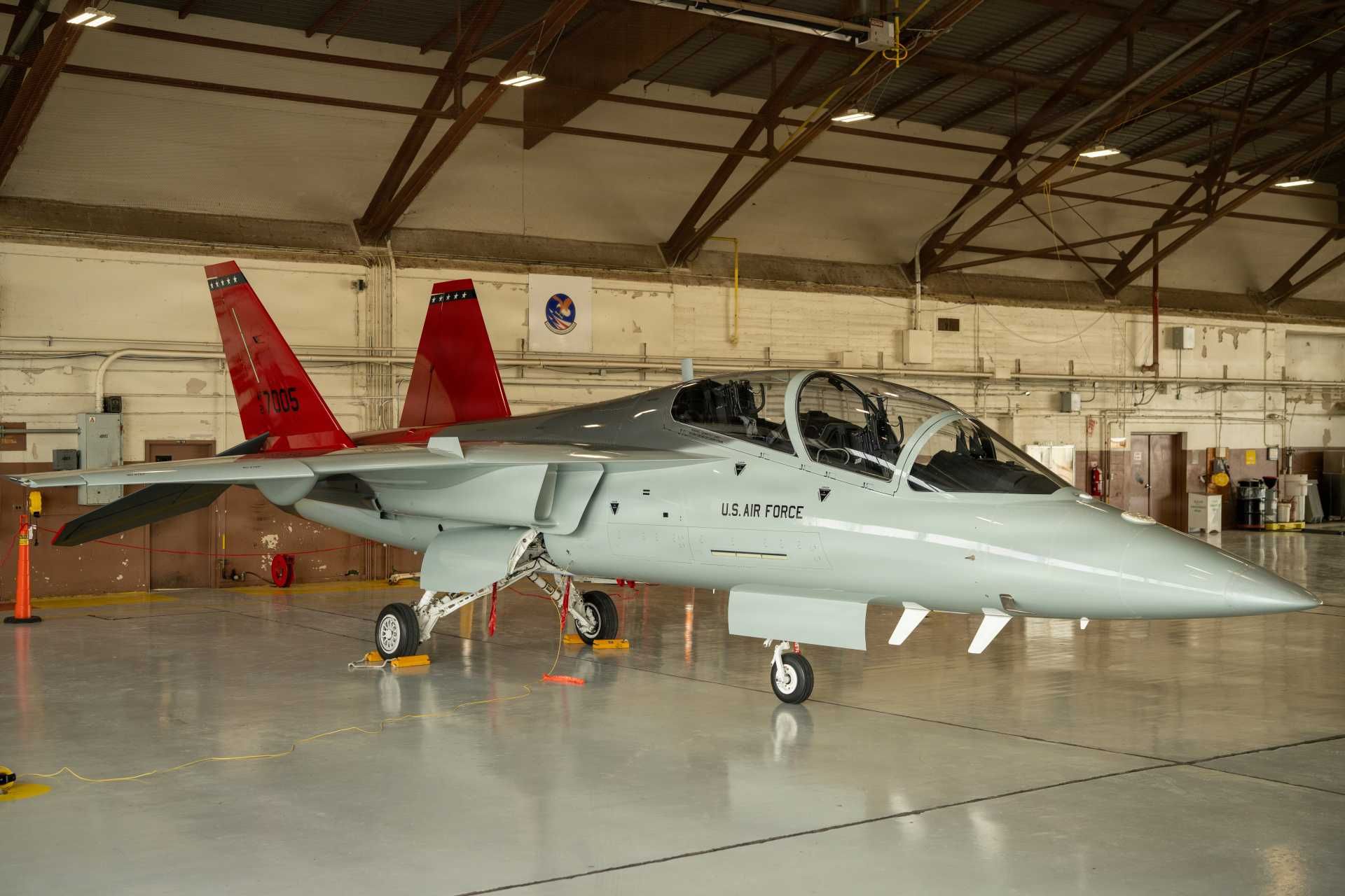 Under the wing of a T-7A Red Hawk inside a U.S. Air Force hangar, new training technologies by Textron Systems aim to equip maintainers with real-world system experience