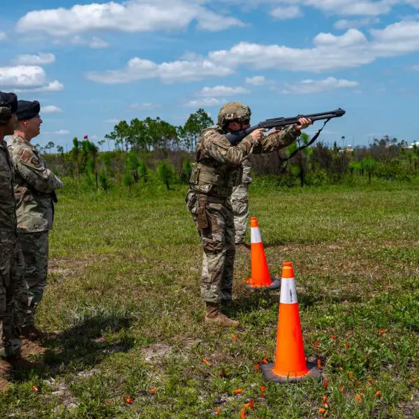 U.S. Air Force Tech. Sgt. Nicholas Rhoades of the 325th Security Forces Squadron demonstrates an M870 shotgun during a counter-drone training event at Tyndall Air Force Base, Florida, on June 3, 2026, as Maj. Gen. Thomas P. Sherman and Senior Master Sgt. Reginald Walters observe. The demonstration highlighted the U.S. Air Force's expanding kinetic capabilities to defeat small unmanned aircraft system threats and strengthen installation defense.