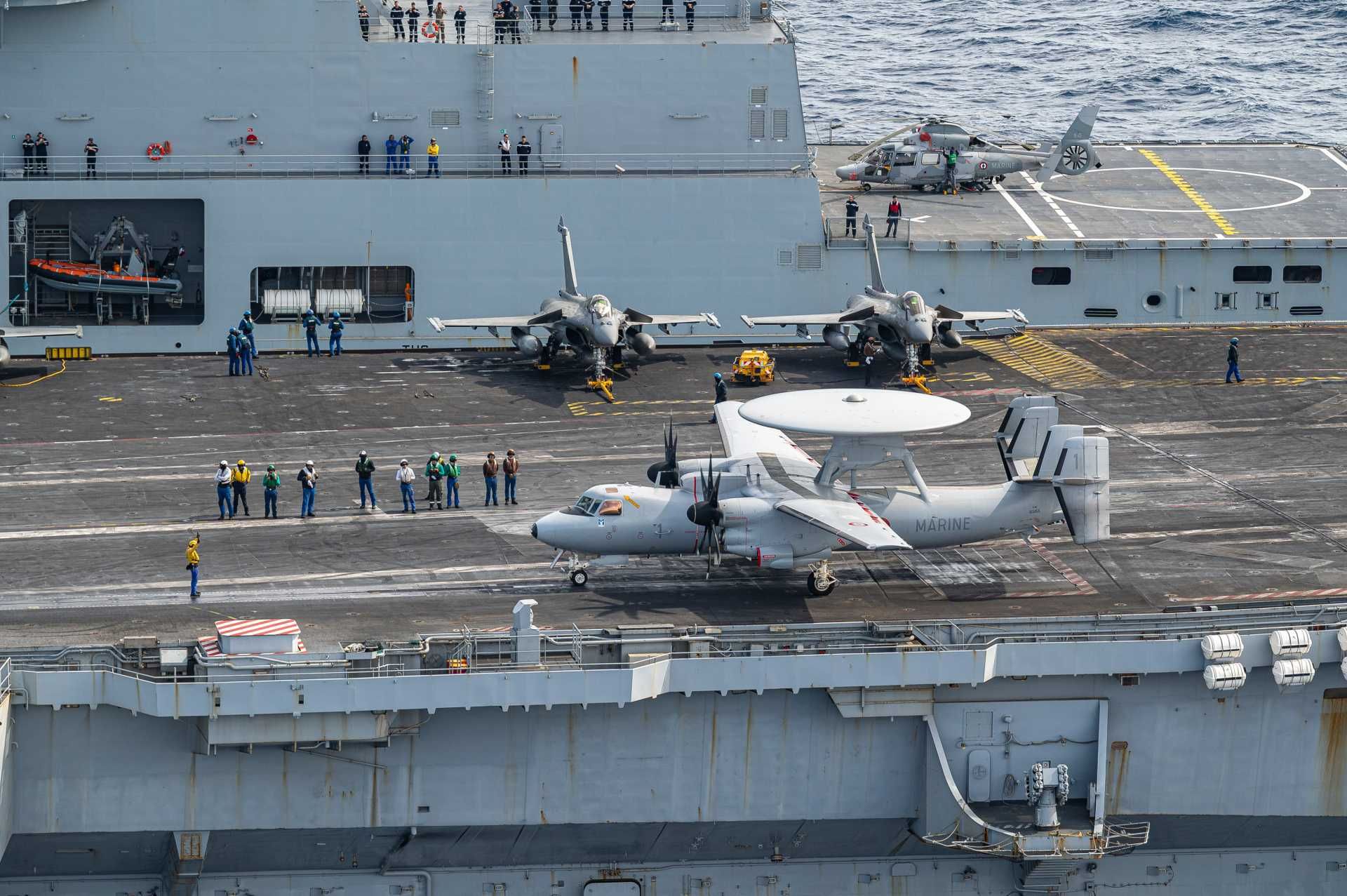 Operating a heavy airborne early warning aircraft like the E-2C Hawkeye imposes high launch energy requirements due to its mass, large wingspan, and drag from the radar dome, while its turboprop engines already provide limited acceleration and reduced climb margin immediately after takeoff. (Picture source: French Navy)