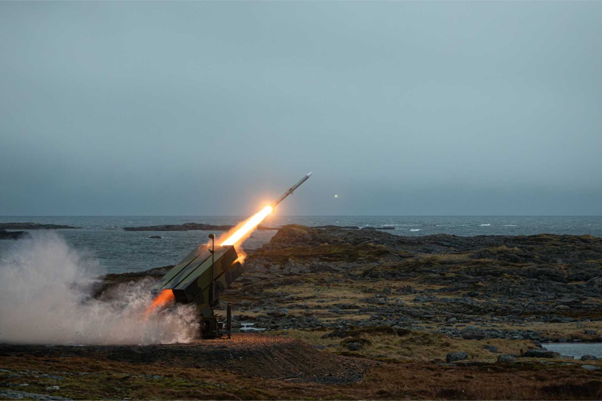 Live-fire demonstration of the NASAMS air defense system using AMRAAM missiles, showcasing rapid target engagement and networked air defense capability against aerial threats.