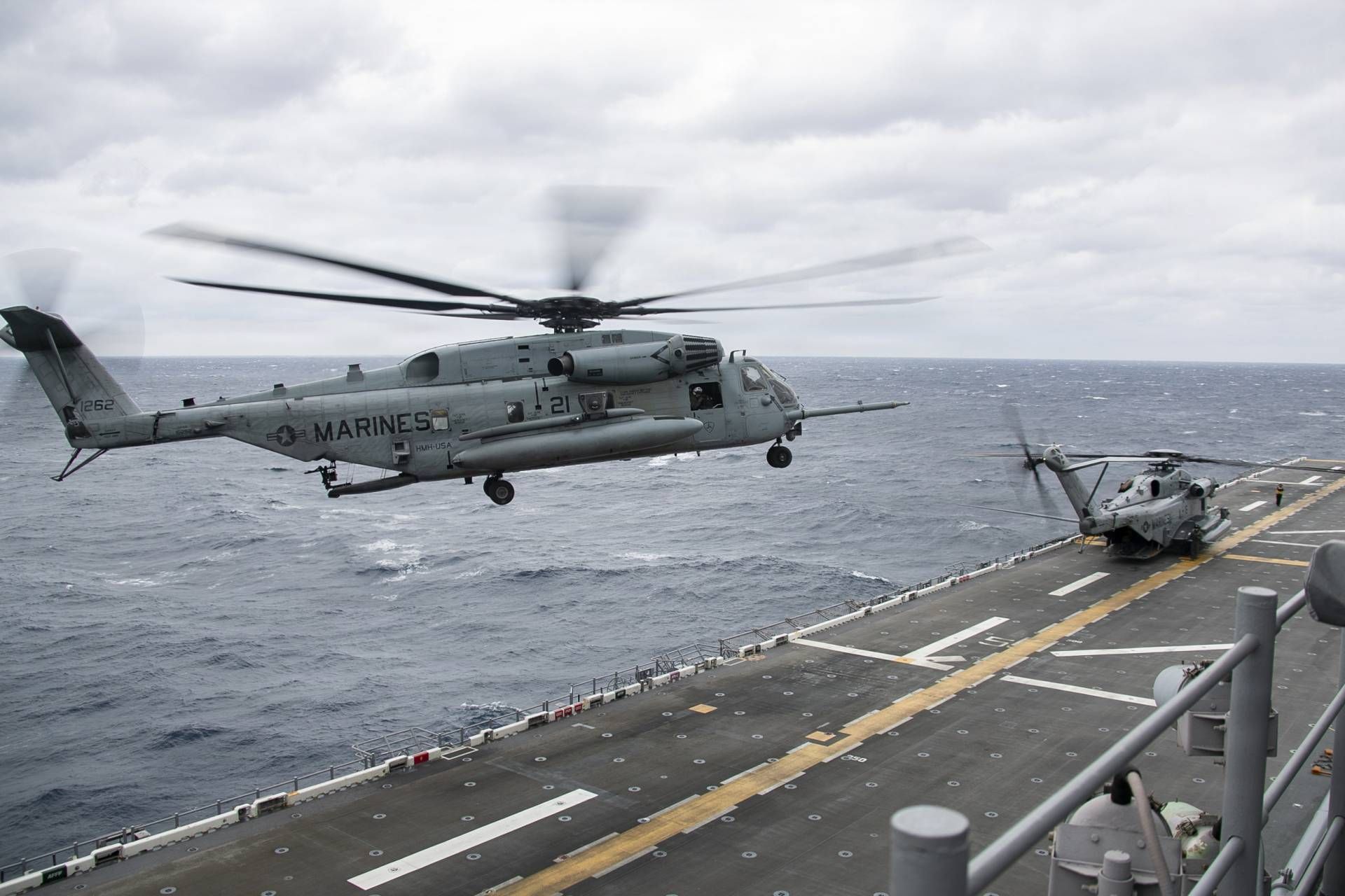 U.S. Marines CH-53 Super Stallion heavy-lift helicopters assigned to Marine Medium Tiltrotor Squadron 265 land on the flight deck of the America-class amphibious assault ship USS Tripoli (LHA 7) during flight operations on January 21, 2026.