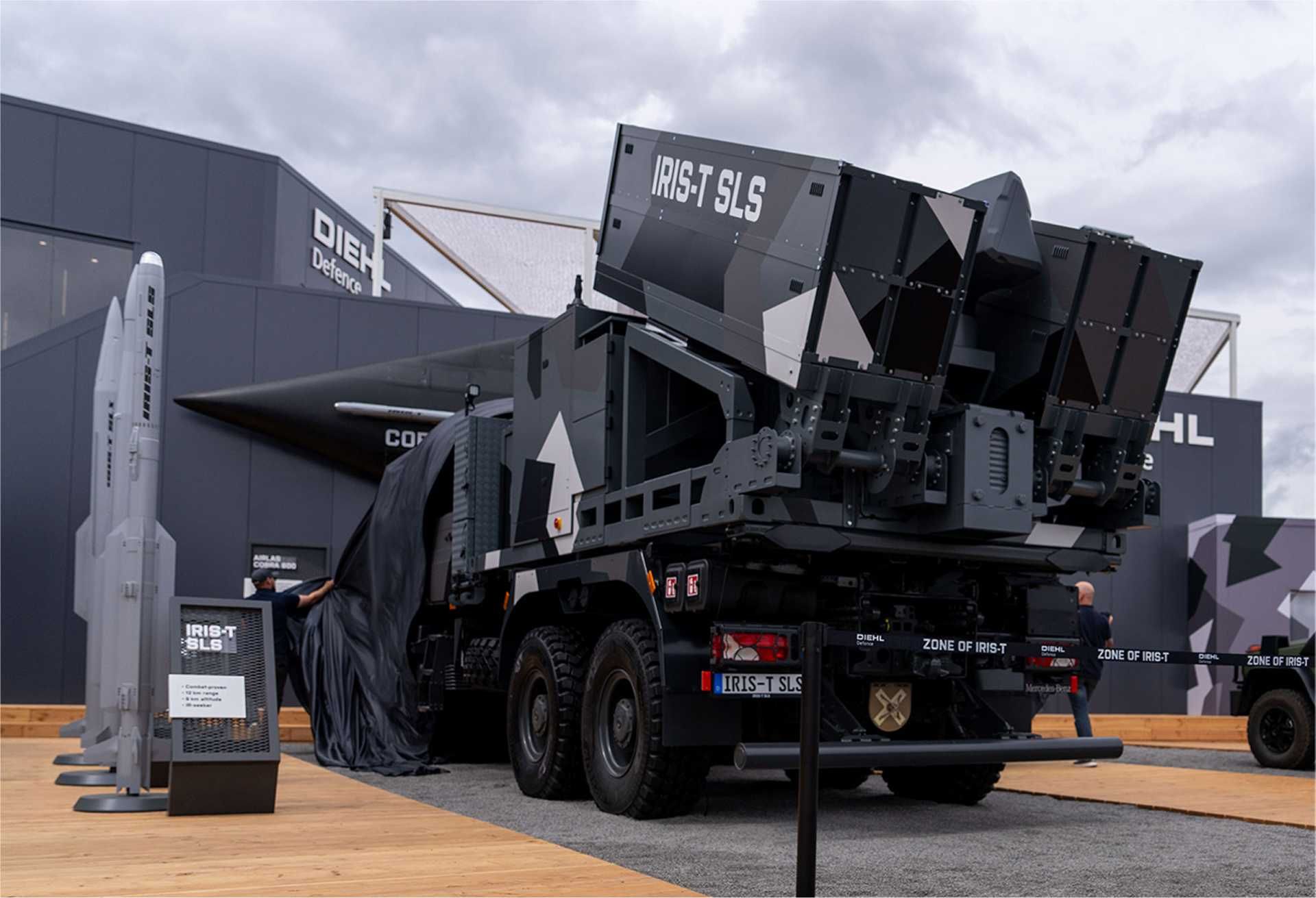 The new IRIS-T SLS Mk 4 short-range air defense system displayed by Diehl Defence at ILA 2026 in Berlin. The highly mobile all-in-one system integrates radar, command-and-control functions, and an eight-missile launcher on a single vehicle, providing rapid-response protection against aircraft, helicopters, cruise missiles, drones, and loitering munitions.