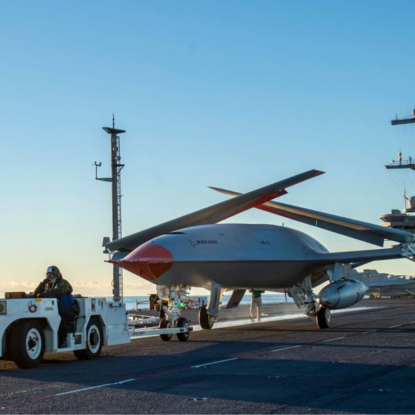 A Boeing unmanned MQ-25 aircraft is given operating directions on the flight deck aboard the aircraft carrier USS George H.W. Bush (Picture source: US DoD)