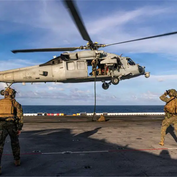 U.S. Marines with the 22nd Marine Expeditionary Unit conduct fast rope insertion drills from a U.S. Navy MH-60S Sea Hawk onto the flight deck of the USS Iwo Jima (LHD 7) in the Caribbean Sea, November 15, 2025.