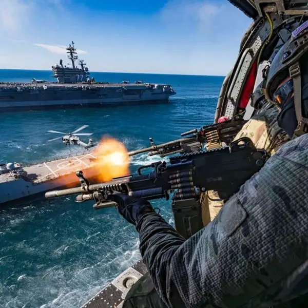 U.S. Navy SEALs fire from an MH-60S Seahawk during the Titans of the Sea Presidential Review, conducting live-fire gunnery over an Arleigh Burke-class destroyer as part of a Navy 250 demonstration showcasing integrated special operations and carrier strike group capabilities (Picture source: U.S. Navy).
