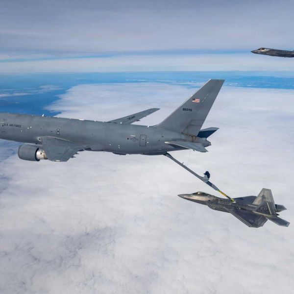 A U.S. Air Force KC-46 Pegasus assigned to the 418th Flight Test Squadron, Global Reach Combined Test Force, conducts aerial refueling operations with an F-22 Raptor from the 411th Flight Test Squadron, Air Dominance Combined Test Force, while an F-35A Lightning II assigned to the 461st Flight Test Squadron, F-35 Integrated Test Force, awaits refueling during integrated flight testing over the Pacific Ocean.