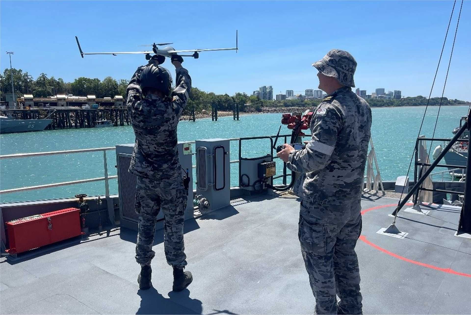 Royal Australian Navy sailors launch the Edge 130 tri-copter drone from the deck of HMAS Cape Pillar during operational trials in Darwin Harbour, showcasing the integration of uncrewed aerial systems into frontline patrol missions.