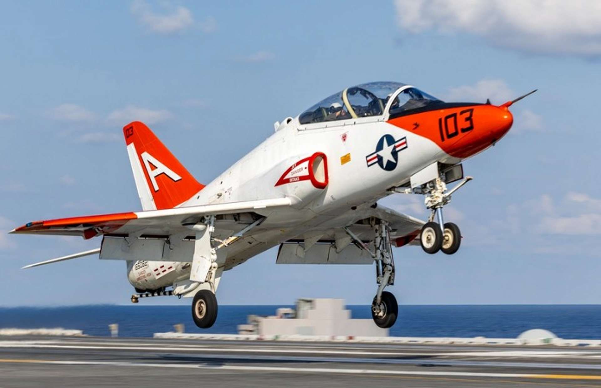 T-45C Goshawk, the Navy’s carrier-capable jet trainer, pairs a glass cockpit and single Adour engine to teach carrier approaches, instruments, formation, and basic fighter maneuvering; its aging fleet is driving the UJTS replacement (Picture source: U.S. DoW).