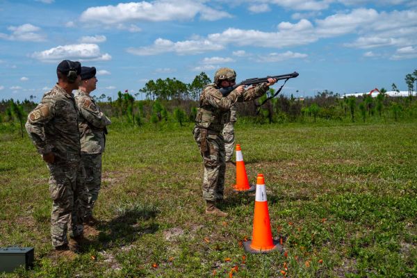 U.S. Air Force Tech. Sgt. Nicholas Rhoades of the 325th Security Forces Squadron demonstrates an M870 shotgun during a counter-drone training event at Tyndall Air Force Base, Florida, on June 3, 2026, as Maj. Gen. Thomas P. Sherman and Senior Master Sgt. Reginald Walters observe. The demonstration highlighted the U.S. Air Force's expanding kinetic capabilities to defeat small unmanned aircraft system threats and strengthen installation defense.