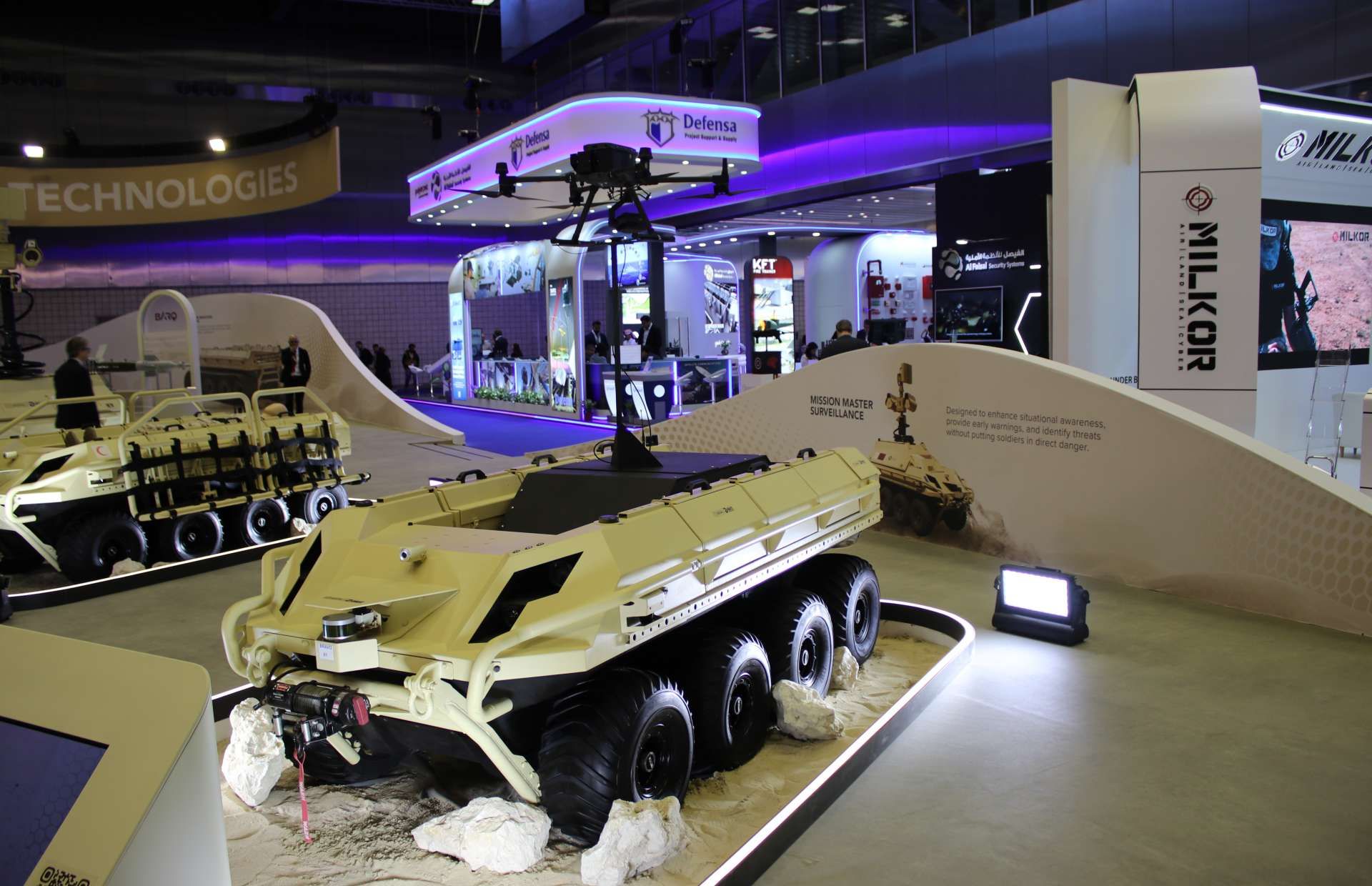 The Mission Master unmanned ground vehicle displayed by Barzan Holdings integrates a fully electric 8x8 UGV with a roof-mounted drone launch and recovery system, enabling mobile, low-signature patrols with persistent aerial surveillance, extended situational awareness, and networked control for base protection, border security, and forward reconnaissance missions (Picture source: Army Recognition Group).