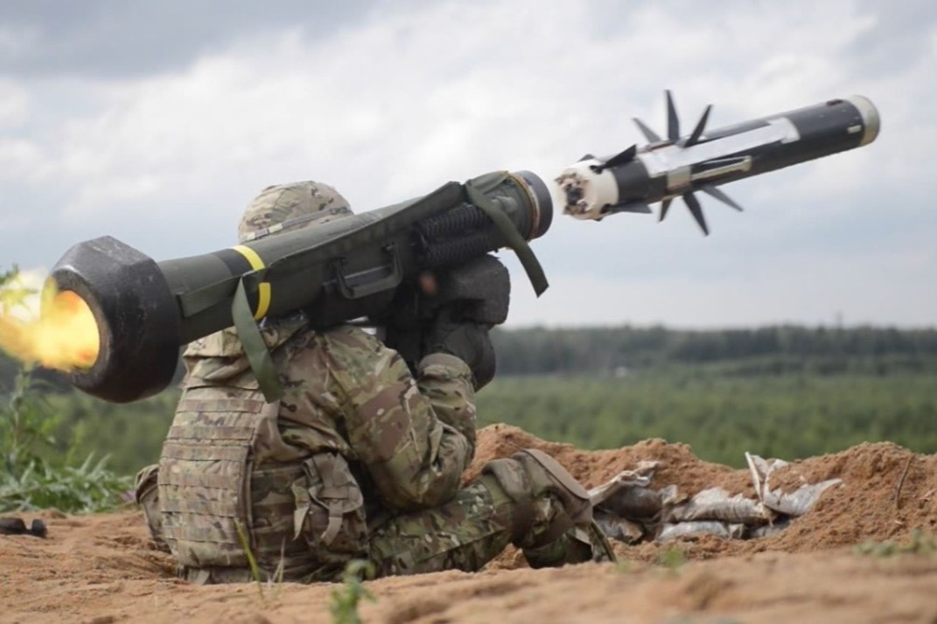 A soldier fires an FGM-148 Javelin, launching the anti-tank missile toward a distant armored target (Picture Source: U.S. Army)