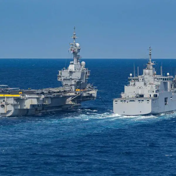 Replenishment-at-sea constrains the carrier to a slower speed range of about 12 to 16 knots and a fixed heading with minimal deviation, preventing it from turning into the wind or accelerating to generate an optimal airflow for the E-2C. (Picture source: French Navy)