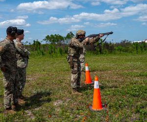 U.S. Air Force Tech. Sgt. Nicholas Rhoades of the 325th Security Forces Squadron demonstrates an M870 shotgun during a counter-drone training event at Tyndall Air Force Base, Florida, on June 3, 2026, as Maj. Gen. Thomas P. Sherman and Senior Master Sgt. Reginald Walters observe. The demonstration highlighted the U.S. Air Force's expanding kinetic capabilities to defeat small unmanned aircraft system threats and strengthen installation defense.