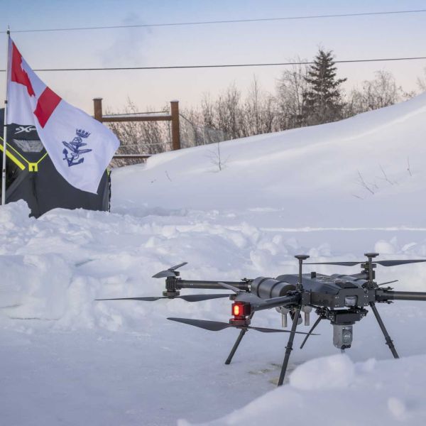An unmanned aerial vehicle displayed alongside a Canadian flag, symbolizing advances in defense innovation and aerospace technologies.