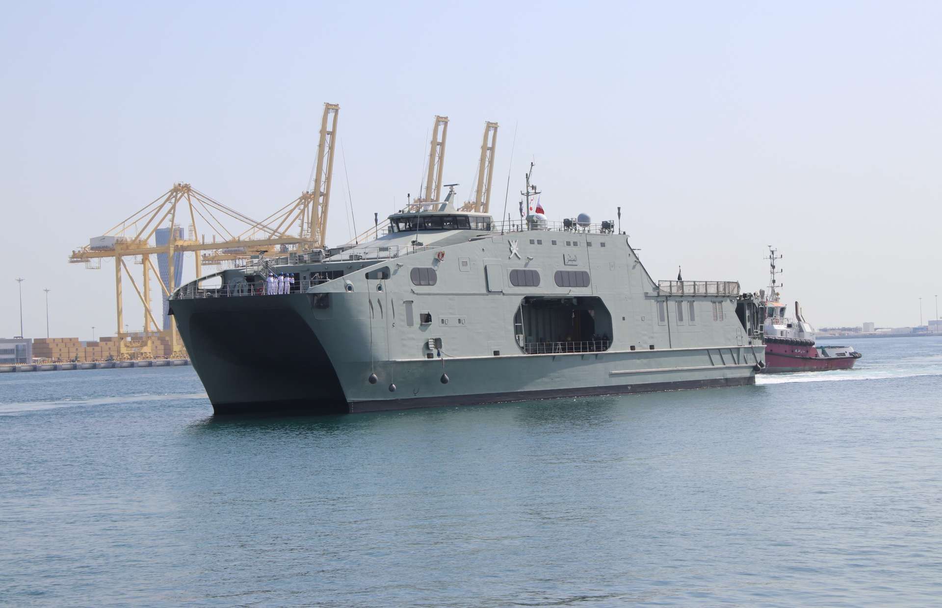 RNOV Al Mubashir (S11) is a 72.5 m high-speed catamaran support ship built to move troops, vehicles, and supplies fast, with a large RO-RO deck, helicopter-capable flight deck, shallow-draft access, and defensive guns for regional security and relief missions (Picture source: Army Recognition Group).