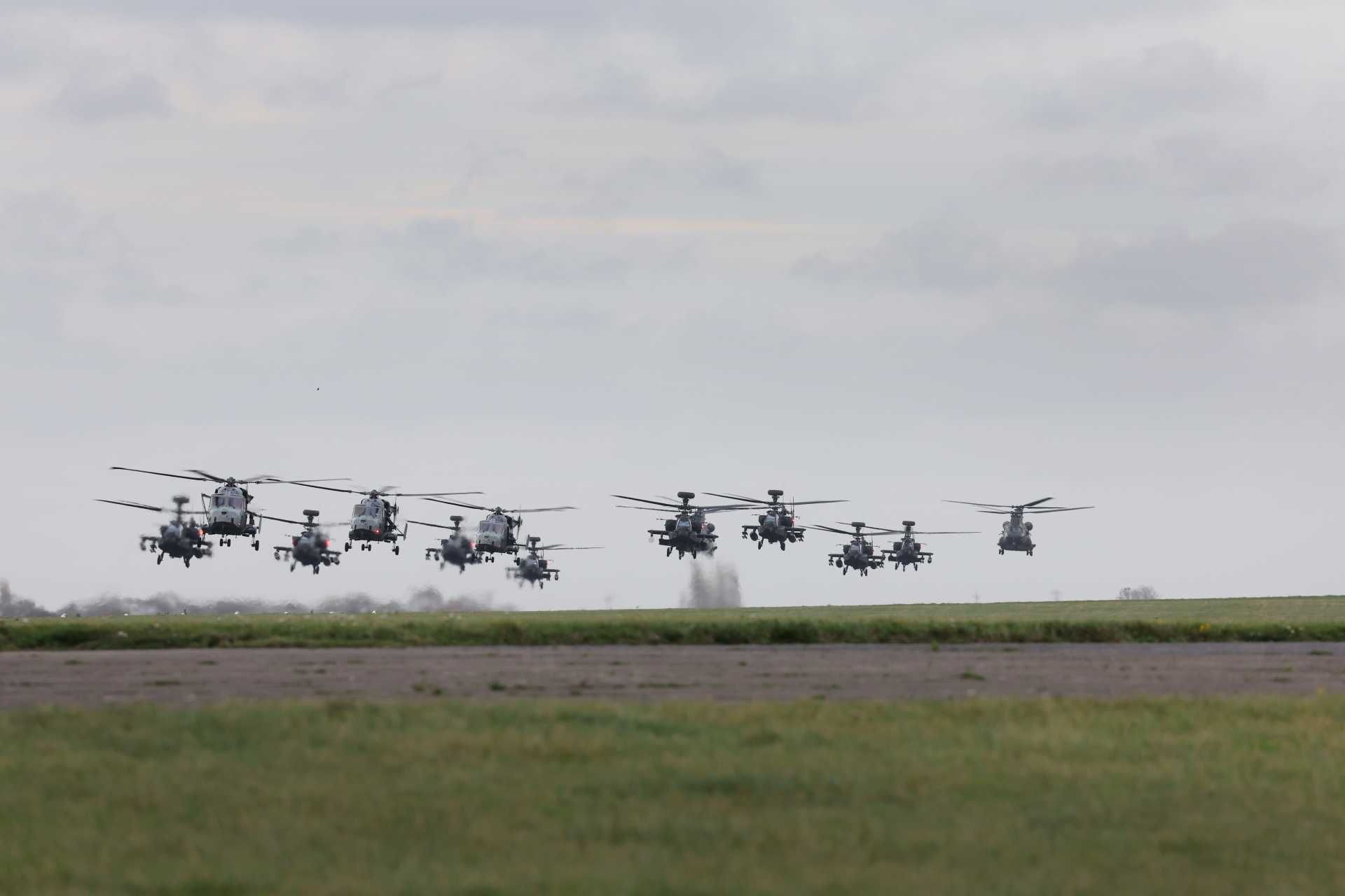 A joint formation of 24 British and French military helicopters, including Apache, Chinook, Gazelle, and Wildcat aircraft, lifts off from Wattisham Flying Station in Suffolk at the start of Exercise Pinion Titan, demonstrating NATO combat readiness and allied aviation coordination.
