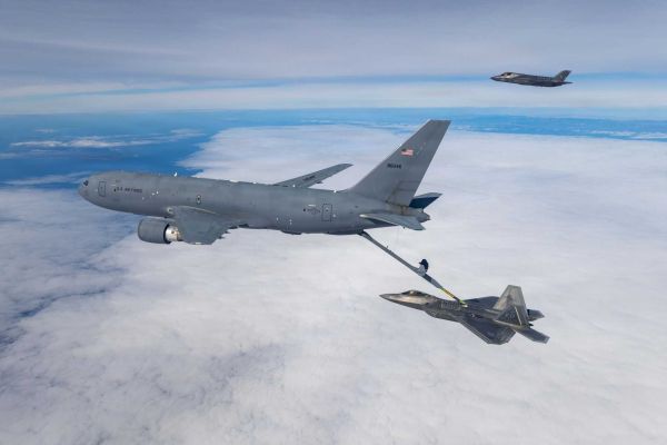A U.S. Air Force KC-46 Pegasus assigned to the 418th Flight Test Squadron, Global Reach Combined Test Force, conducts aerial refueling operations with an F-22 Raptor from the 411th Flight Test Squadron, Air Dominance Combined Test Force, while an F-35A Lightning II assigned to the 461st Flight Test Squadron, F-35 Integrated Test Force, awaits refueling during integrated flight testing over the Pacific Ocean.